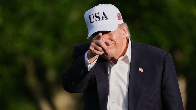 El presidente de Estados Unidos, Donald Trump, hace un gesto a la prensa mientras camina por...