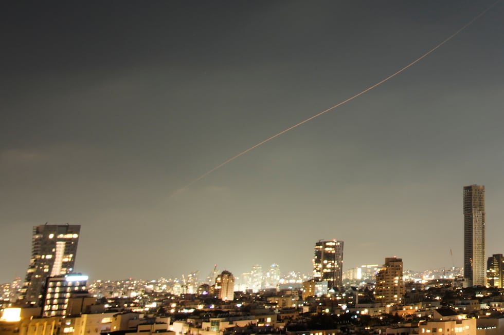 A projectile streaks through the sky over central Israel during an Iranian missile attack,...