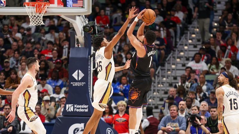 Phoenix Suns guard Devin Booker (1) shoots a jumper over New Orleans Pelicans forward Trey...